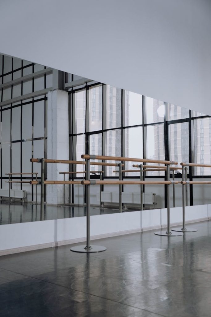 Modern ballet studio featuring mirrored walls and ballet barres, perfect for dance practice.